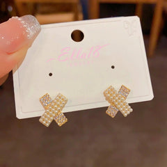 Close-up detail of the sparkling zircons and plating on the gold cross earrings