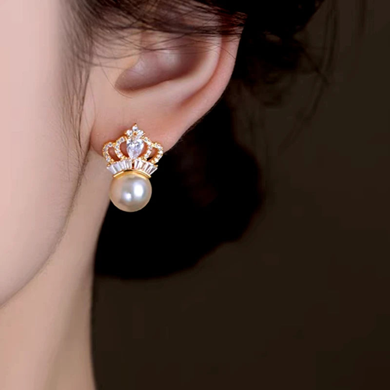 Model showcasing the dangle and style of the 14K Gold-Plated Elegant Zircon Pearl Crown Pearl Earrings