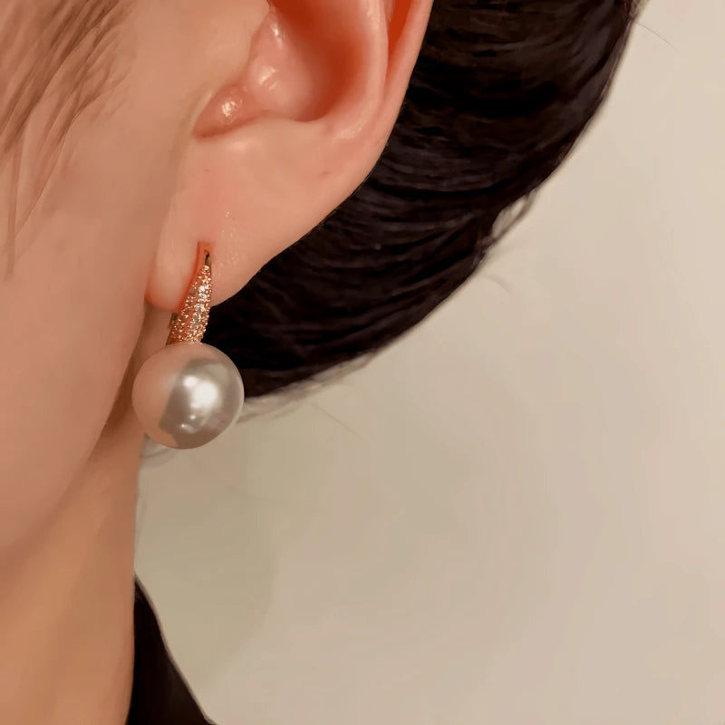 Model showcasing the dangle and style of the 14K Gold-Plated Elegant Zircon Pearl Ear Hooks