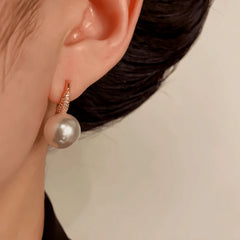 Model showcasing the dangle and style of the 14K Gold-Plated Elegant Zircon Pearl Ear Hooks