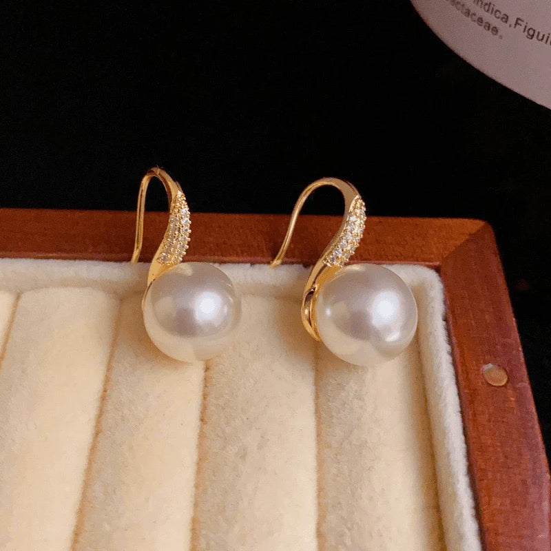 Close-up detail of the sparkling zircons and plating on the gold pearl earrings