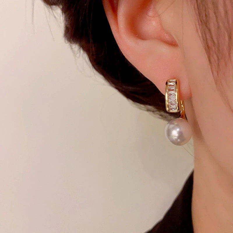 Model showcasing the dangle and style of the 14K Gold-Plated Elegant Zircon Pearl Earrings