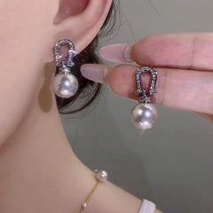 Model showcasing the dangle and style of the 14K Gold-Plated Elegant Zircon Pearl Earrings