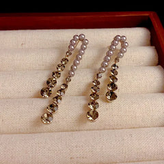 Close-up detail of the sparkling zircons and plating on the gold pearl earrings