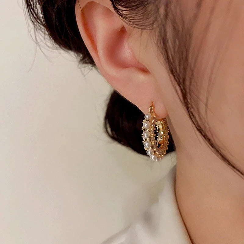 Model showcasing the dangle and style of the 14K Gold-Plated Elegant Zircon Pearl Hoop Earrings