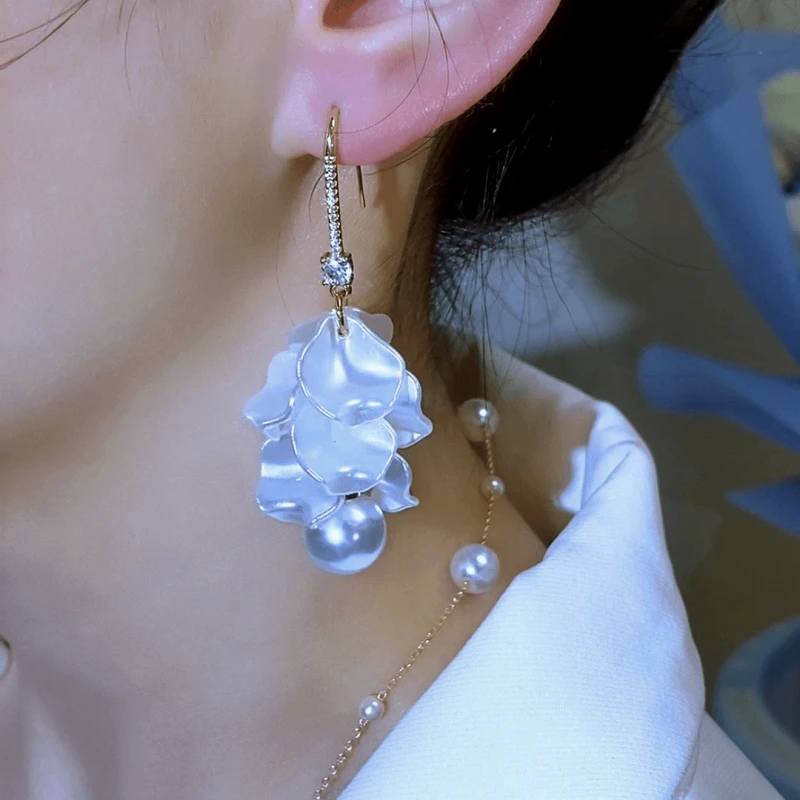 Model showcasing the dangle and style of the 14K Gold-Plated Elegant Zircon Pearl Petal Tassel Earrings