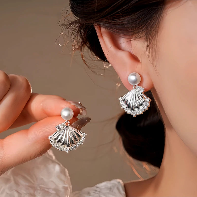 Model showcasing the dangle and style of the 14K Gold-Plated Elegant Zircon Pearl Shell Earrings