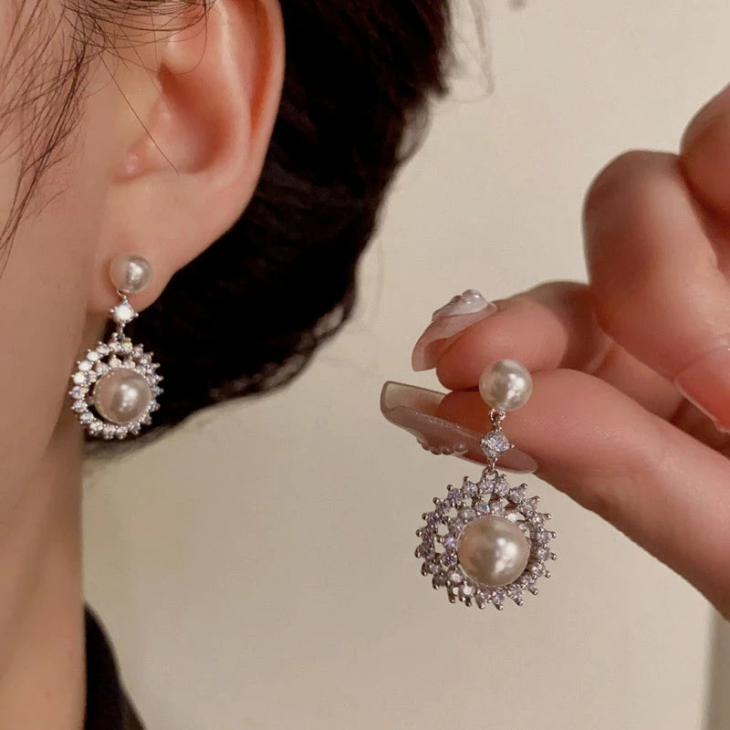 Model showcasing the dangle and style of the 14K Gold-Plated Elegant Zircon Pearl Sunflower Earrings