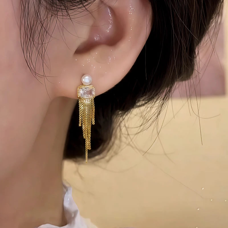 Close-up detail of the sparkling zircons and plating on the gold tassel earrings
