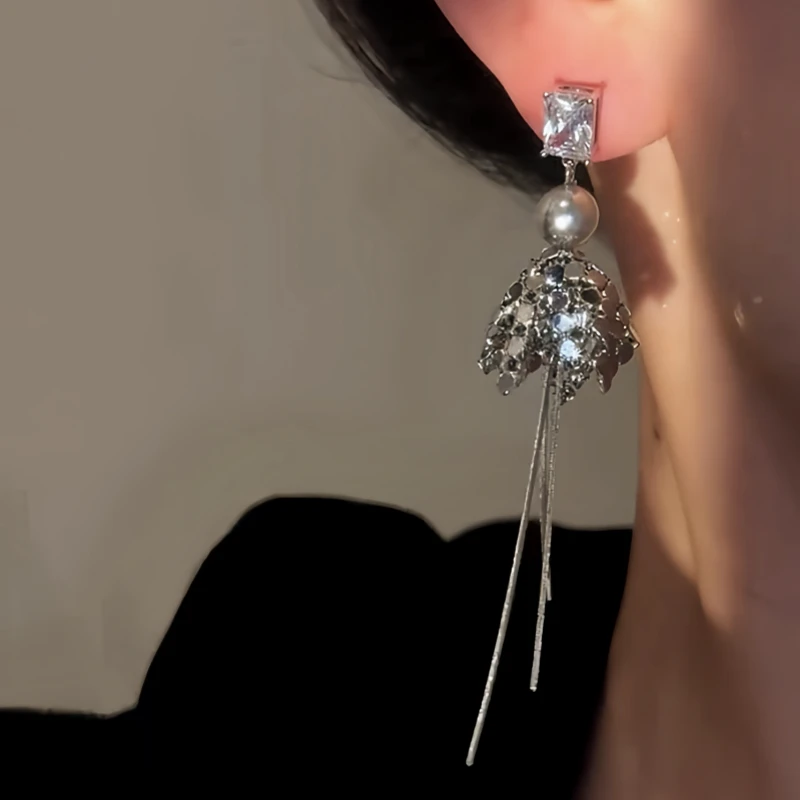 Close-up detail of the sparkling zircons and plating on the gold tassel earrings