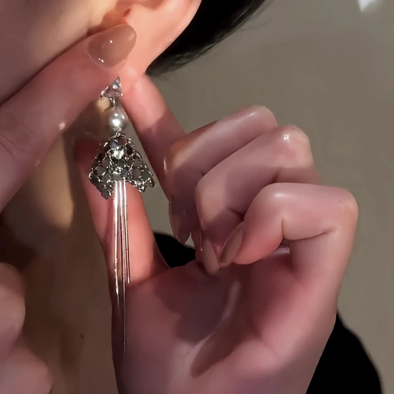 Model showcasing the dangle and style of the 14K Gold-Plated Elegant Zircon Pearl Tassel Earrings