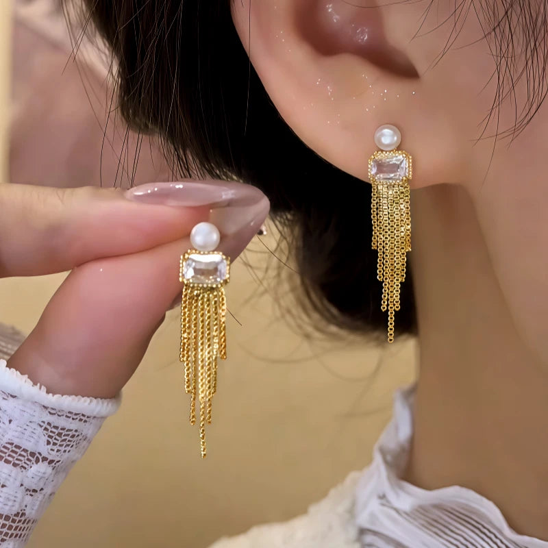 Model showcasing the dangle and style of the 14K Gold-Plated Elegant Zircon Pearl Tassel Earrings