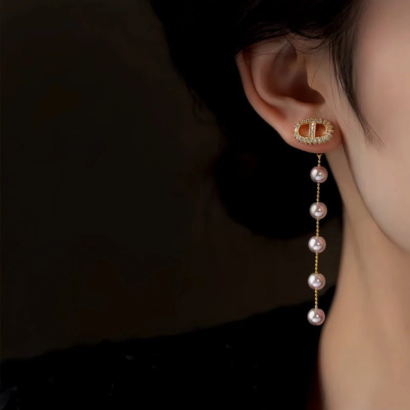 Model showcasing the dangle and style of the 14K Gold-Plated Elegant Zircon Pig Nose Pearl Earrings