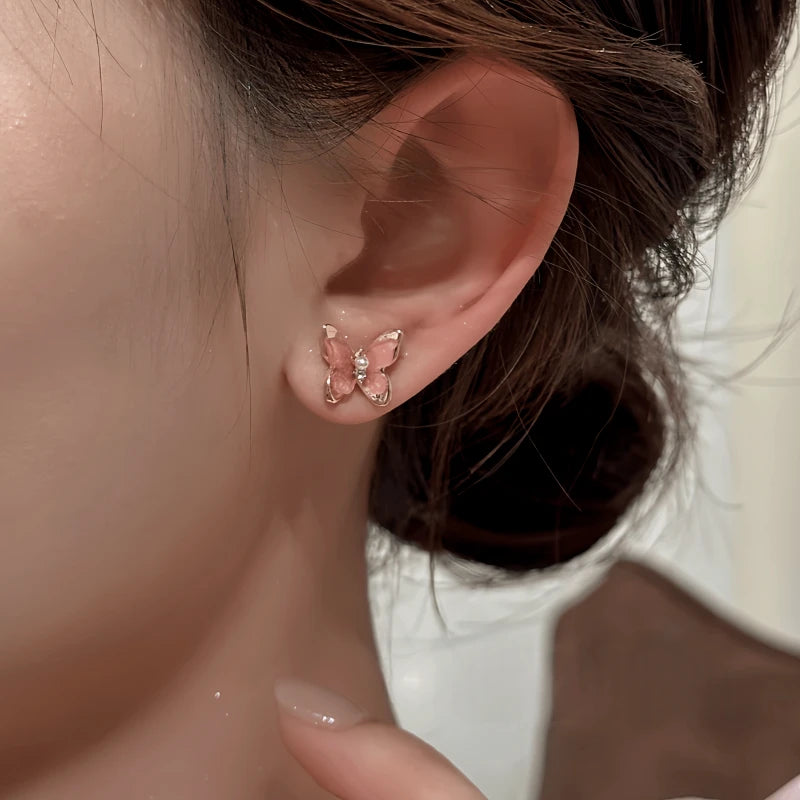 Model showcasing the dangle and style of the 14K Gold-Plated Elegant Zircon Pink Butterfly Stud Earrings