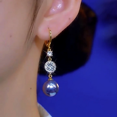 Model showcasing the dangle and style of the 14K Gold-Plated Elegant Zircon Purple Pearl Earrings