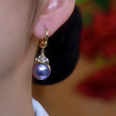 Model showcasing the dangle and style of the 14K Gold-Plated Elegant Zircon Purple Pearl Earrings