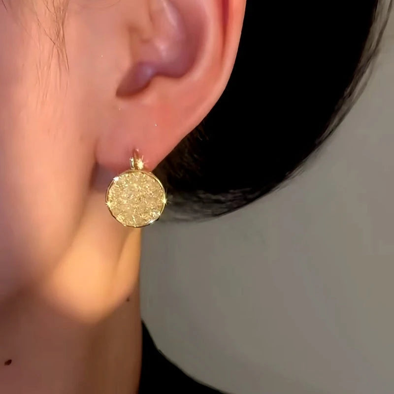 Model showcasing the dangle and style of the 14K Gold-Plated Elegant Zircon Round Earrings