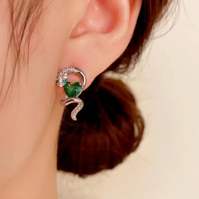 Model showcasing the dangle and style of the 14K Gold-Plated Elegant Zircon Snake-Shaped Emerald Heart Earrings