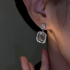 Model showcasing the dangle and style of the 14K Gold-Plated Elegant Zircon Square Diamond Earrings