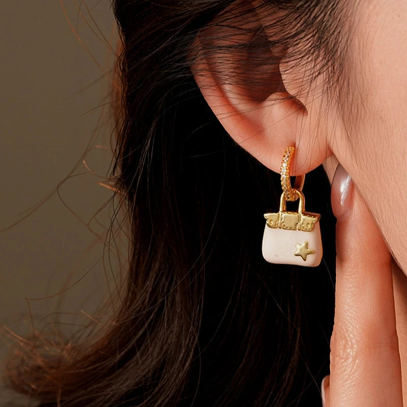 Model showcasing the dangle and style of the 14K Gold-Plated Elegant Zircon Star Bag Earrings