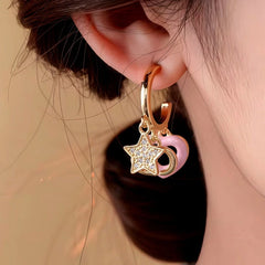 Model showcasing the dangle and style of the 14K Gold-Plated Elegant Zircon Star Pig Nose Pink Heart Tassel Earrings