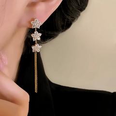Model showcasing the dangle and style of the 14K Gold-Plated Elegant Zircon Star Tassel Earrings