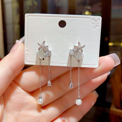 Angled view of the 14K Gold-Plated Elegant Zircon Starfish Shell Tassel Earrings