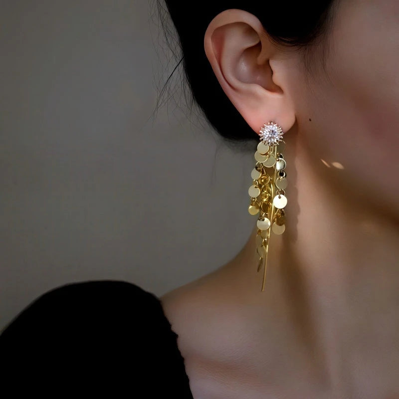 Model showcasing the dangle and style of the 14K Gold-Plated Elegant Zircon Sun Flower Tassel Earrings