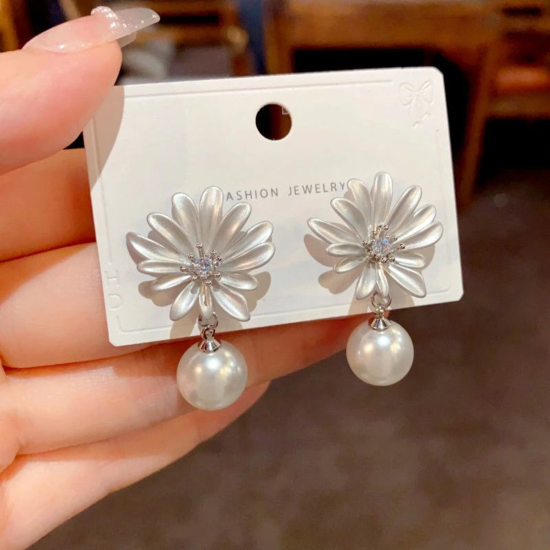Angled view of the 14K Gold-Plated Elegant Zircon Sunflower Pearl Earrings