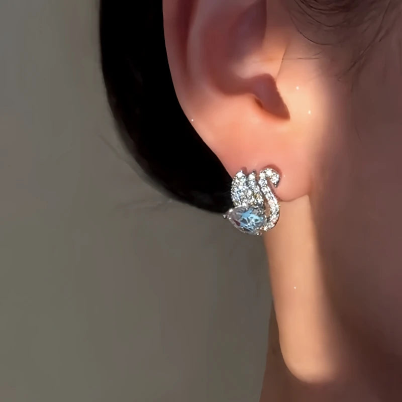 Model showcasing the dangle and style of the 14K Gold-Plated Elegant Zircon Swan Earrings