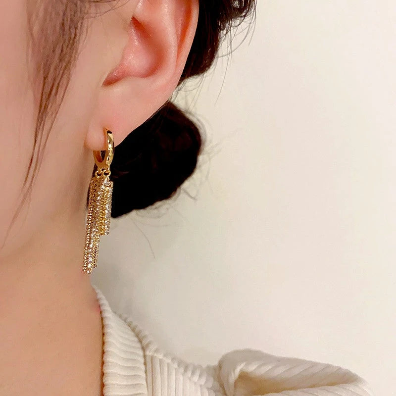 Model showcasing the dangle and style of the 14K Gold-Plated Elegant Zircon Tassel Earrings