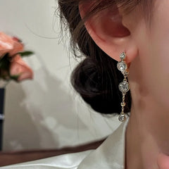Model showcasing the dangle and style of the 14K Gold-Plated Elegant Zircon Tassel Earrings