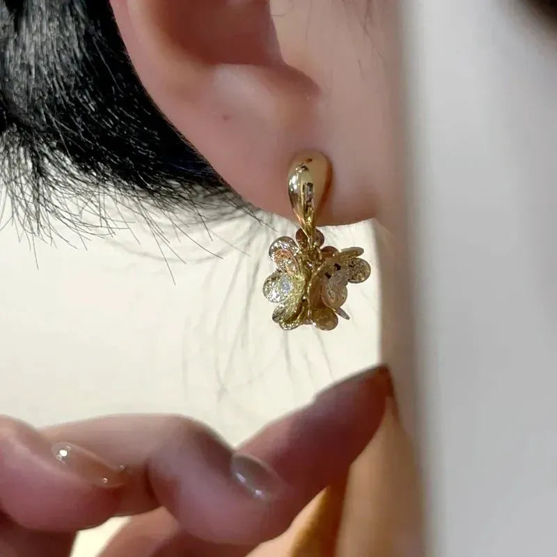 Model showcasing the dangle and style of the 14K Gold-Plated Elegant Zircon Tassel Flower Earrings