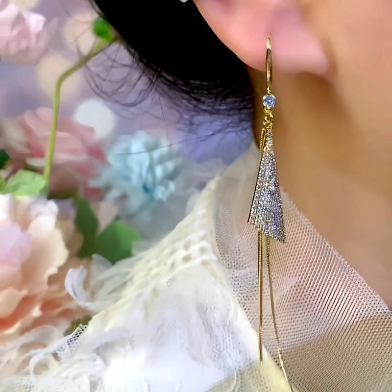 Model showcasing the dangle and style of the 14K Gold-Plated Elegant Zircon Triangle Long Tassel Hook Earrings