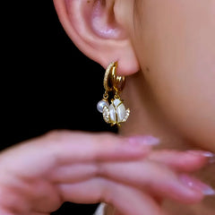 Model showcasing the dangle and style of the 14K Gold-Plated Elegant Zircon Tulip Pearl Earrings