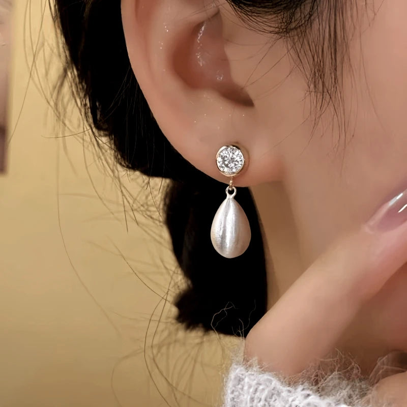 Model showcasing the dangle and style of the 14K Gold-Plated Elegant Zircon Water Drop Earrings