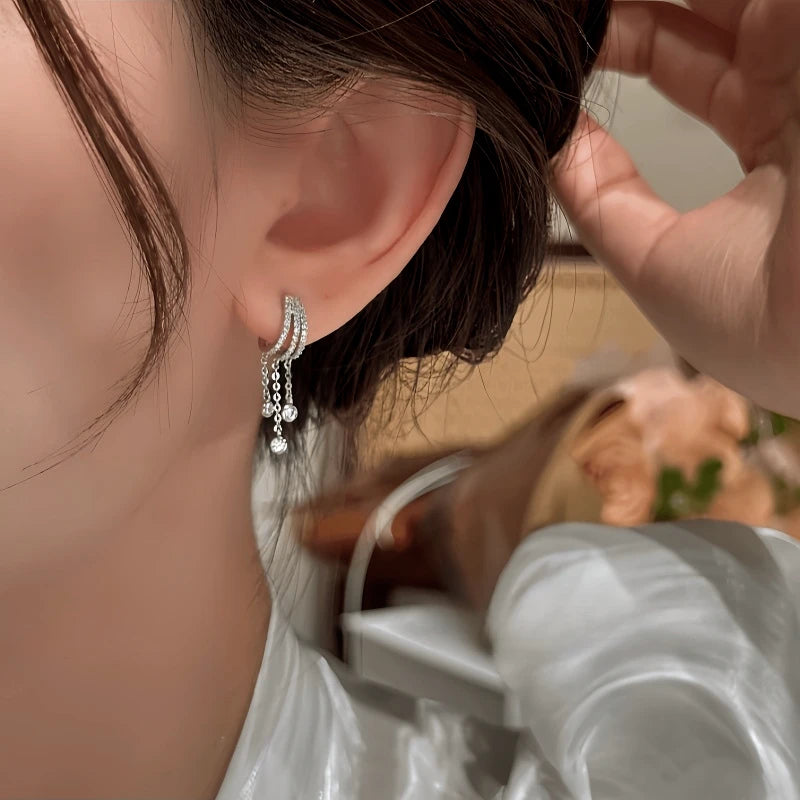 Model showcasing the dangle and style of the 14K Gold-Plated Elegant Zircon Water Drop Tassel Earrings