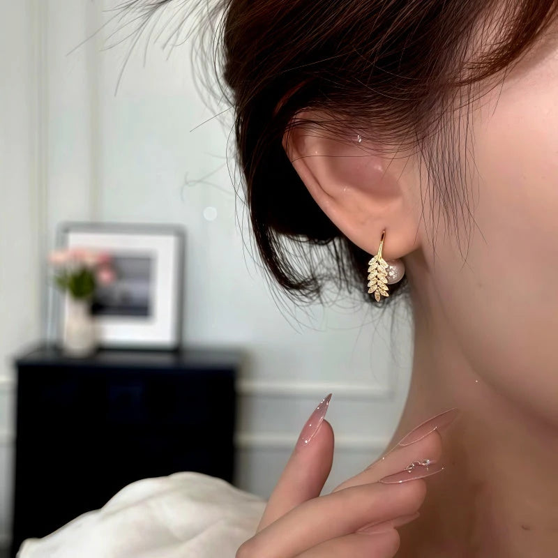 Model showcasing the dangle and style of the 14K Gold-Plated Elegant Zircon Wheat Bead Jacket Earrings