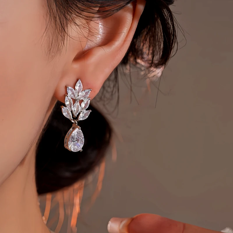 Model showcasing the dangle and style of the 14K Gold-Plated Elegant Zircon Wheat Water Drop Earrings