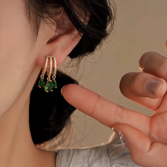 Model showcasing the dangle and style of the 14K Gold-Plated Elegant Green Zircon Diamond Tassel Earrings