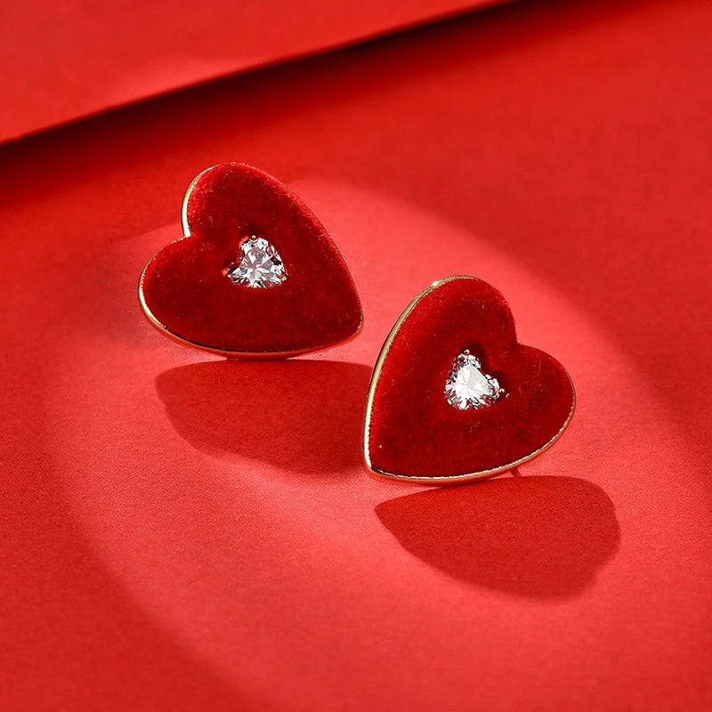 Model showcasing the dangle and style of the 14K Gold-Plated Elegant Zircon Wine Red Heart Stud Earrings