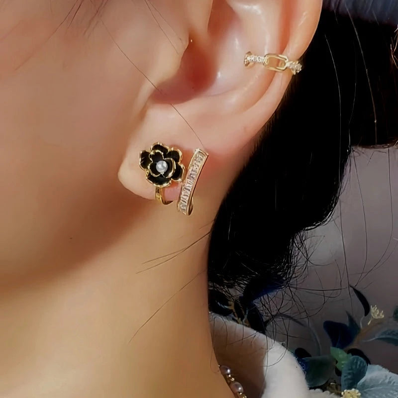 Model showcasing the dangle and style of the 14K Gold-Plated Exquisite Black Camellia Zircon Stud Earrings