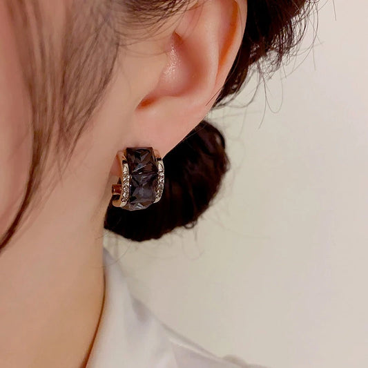 Model showcasing the dangle and style of the 14K Gold-Plated Exquisite Black Square Diamond Earrings