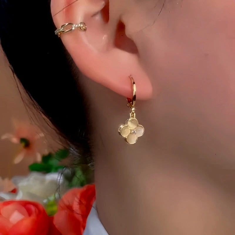 Model showcasing the dangle and style of the 14K Gold-Plated Exquisite Cat's Eye Flower Earrings