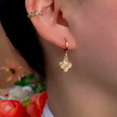 Model showcasing the dangle and style of the 14K Gold-Plated Exquisite Cat's Eye Flower Earrings