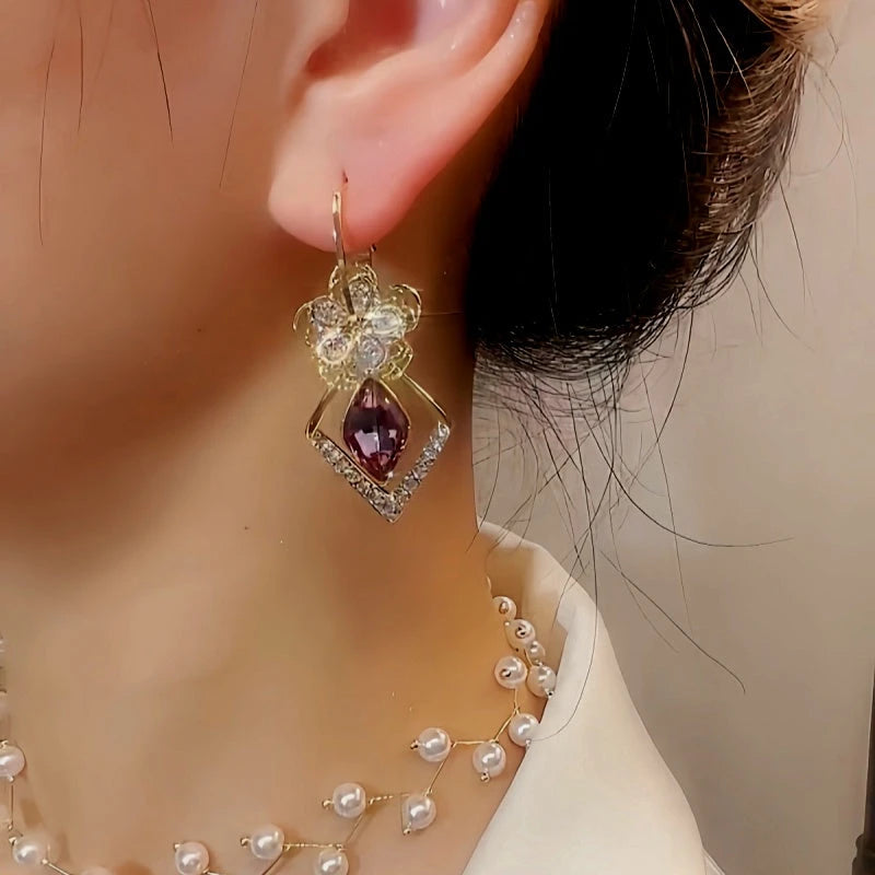 Model showcasing the dangle and style of the 14K Gold-Plated Exquisite Diamond Flower Crystal Earrings