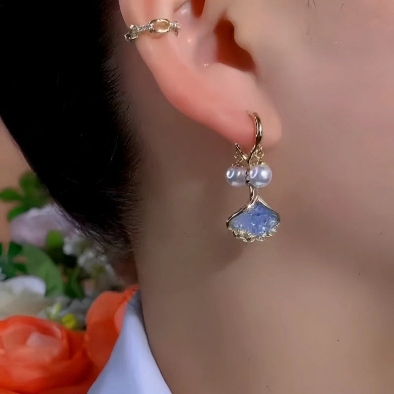 Model showcasing the dangle and style of the 14K Gold-Plated Exquisite Ginkgo Leaf Pearl Earrings