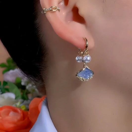 Model showcasing the dangle and style of the 14K Gold-Plated Exquisite Ginkgo Leaf Pearl Earrings