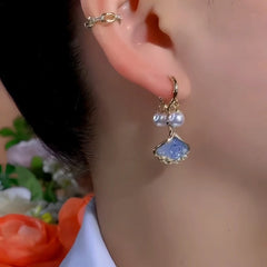 Model showcasing the dangle and style of the 14K Gold-Plated Exquisite Ginkgo Leaf Pearl Earrings