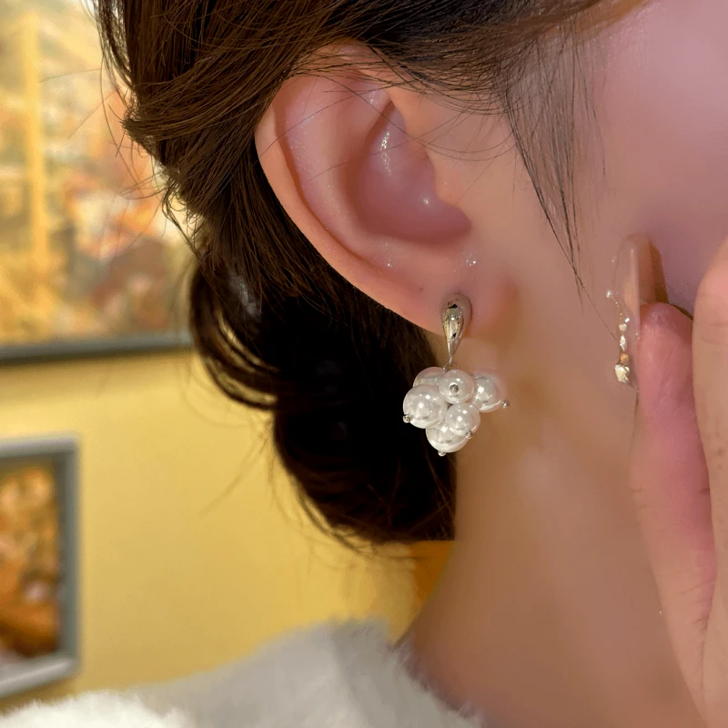 Model showcasing the dangle and style of the 14K Gold-Plated Exquisite Grape Bead Tassel Earrings